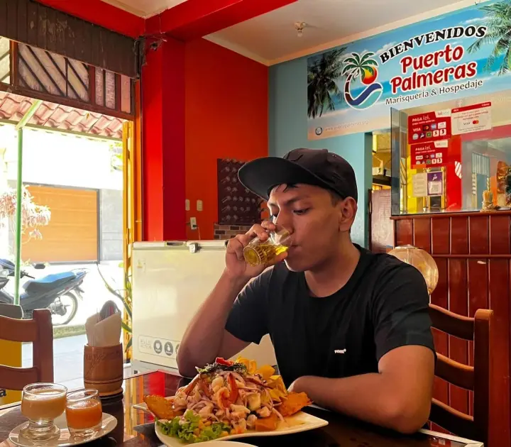 Cliente disfrutando un ceviche con una bebida helada
